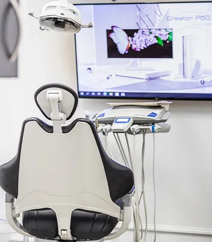 A treatment room, with a screen above the chair showing a 3D scan.